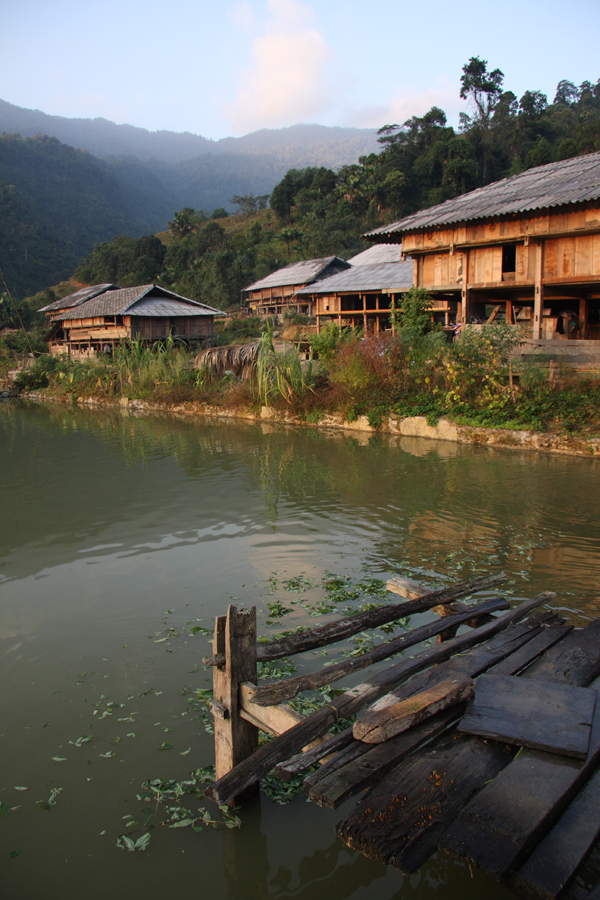 Dawn in a stilt house village in the middle of nowhere. We had to fill rivers with rocks 4 or 5 times, in the dark, just to get our 4WD vehicle up to this place, where we were expected for a homestay with the locals. The WC, which projected out over this pond, had a palm leaf for a door and last night's supper made good eating for the carp directly below.